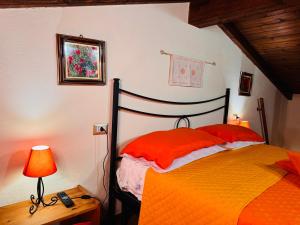 a bedroom with a bed with red sheets and a lamp at Lilly's House in Monteponi +5 photos