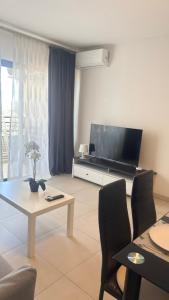 a living room with a television and a table and chairs at Cozy Ocean view 1 BDR APT, Club Paraiso in Playa Paraiso