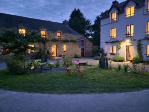a large building with a table and chairs in the yard at Gîte - Le Moulin Bernard - Béganne in Béganne