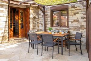a patio with a wooden table and chairs at Portaria Heritage House in Portaria