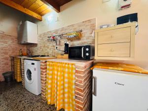 a kitchen with a washing machine and a microwave at Lilly's House in Monteponi