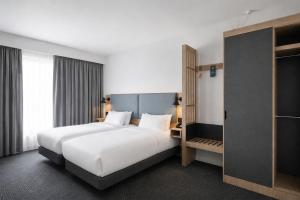 a hotel room with two beds and a closet at Holiday Inn London Luton North in Luton +44 photos