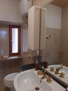 a bathroom with a sink and a toilet and a mirror at La Torretta in Barga
