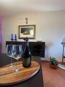 a bottle of wine and two wine glasses on a counter at La Torretta in Barga +23 photos