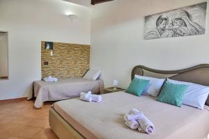 two beds with towels on top of them in a room at Villa Mendolia in Villaggio Mosè