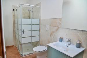 a bathroom with a shower and a toilet and a sink at Villa Mendolia in Villaggio Mosè +3 photos