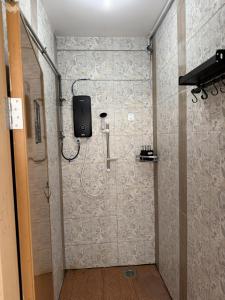 a bathroom with a shower with a phone on the wall at 5 Minutes Away Airport Lodge in Putatan