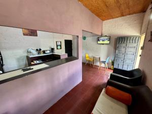 a room with a counter and a kitchen with chairs at Alojamiento Blankyta in Ahuachapán
