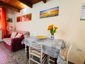 a dining room table with a vase of flowers on it at Lilly's House in Monteponi