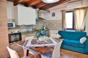 a living room with a table and a blue couch at Villa Mendolia in Villaggio Mosè