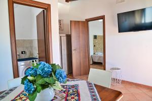 a dining room with a table and a vase of blue flowers at Villa Mendolia in Villaggio Mosè