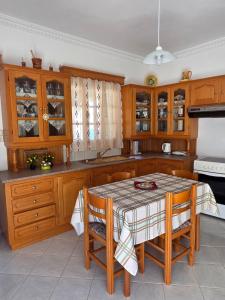 a kitchen with wooden cabinets and a table with chairs at Emporios Blue Apartment in Emborios