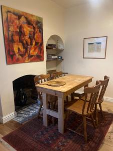 a wooden table and chairs in a room with a fireplace at Mansfield House in Norwich