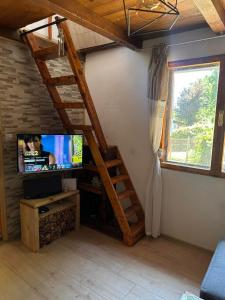 a living room with a tv and a staircase in a house at Two Olives Vacation Homes in Slatina Varoš