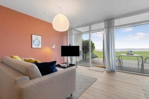 a living room with a couch and a large window at 84286-Ebeltoft-Ndr-Strandvej-3-M in Ebeltoft