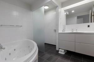 a white bathroom with a tub and a sink at 84286-Ebeltoft-Ndr-Strandvej-3-M in Ebeltoft +22 photos