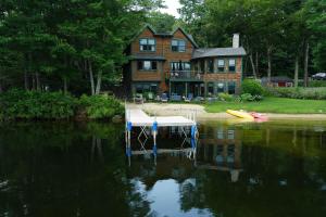ein Haus mit einem Steg im Wasser davor in der Unterkunft Casco Cottage in Casco