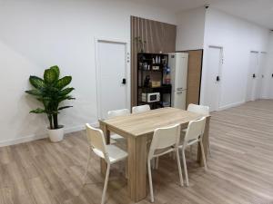 a dining room with a wooden table and white chairs at Hostal NV Palacio Congresos in Málaga +26 photos