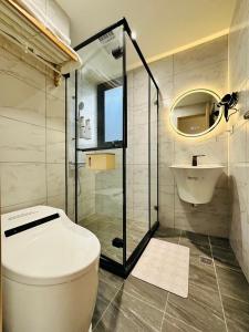 a bathroom with a toilet and a shower and a sink at mini嵐輕旅 in Guanyin +17 photos