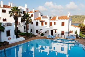 a villa with a swimming pool in front of a house at Comitas Tramontana Park in Fornells