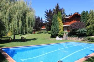 a swimming pool in a yard next to a house at New listing! House with pool and garden, Urús in Urus
