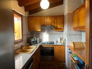 a kitchen with wooden cabinets and a sink and a stove at New listing! House with pool and garden, Urús in Urus