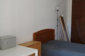 a bedroom with a bed and a desk with a tv at apartamento 2000 in Algés