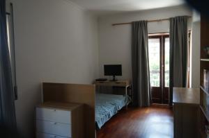 a bedroom with a bed and a desk with a computer at apartamento 2000 in Algés