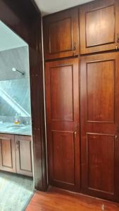 a bathroom with a large wooden door and a sink at Hospedagem Jardim Social,Quartos Econômicos e Suítes, Estacionamento Grátis in Curitiba
