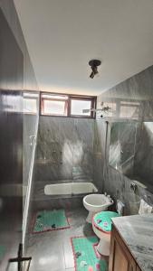 a bathroom with a tub and a toilet and a sink at Hospedagem Jardim Social,Quartos Econômicos e Suítes, Estacionamento Grátis in Curitiba