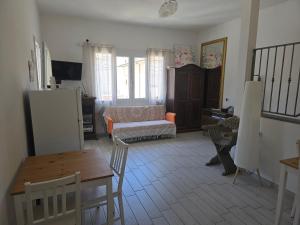 a living room with a table and a couch at camera vicino a mare e pineta in Follonica +9 photos