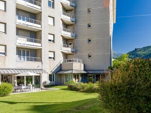 an apartment building with a lawn in front of it at Séjours & Affaires Grenoble Marie Curie in Grenoble
