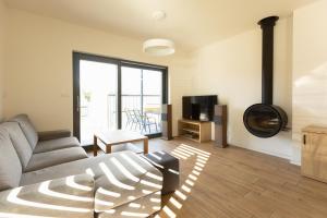 a living room with a couch and a television at Lipno Verde in Lipno nad Vltavou