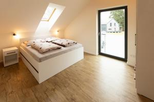 a bedroom with a white bed in a room at Lipno Verde in Lipno nad Vltavou