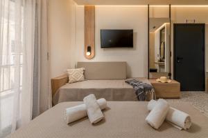 a hotel room with two beds and a television at Six Doors in Pefkochori