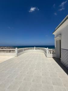 a large patio with the ocean in the background at Villa rafraf in Rafrāf