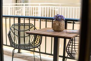 a table and chairs on a balcony with a vase of flowers at Six Doors in Pefkochori +17 photos