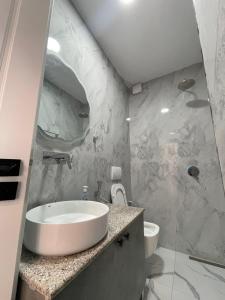 a bathroom with a sink and a shower at Azzurre Premium Aparthotel in Sarandë +32 photos