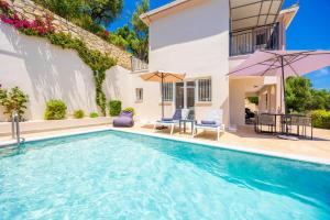 a swimming pool in front of a house at Villa Dimi in Tsilivi
