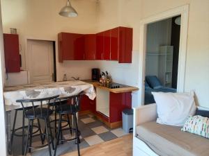 a kitchen with red cabinets and a table in a room at Bellevue in Carbon-Blanc