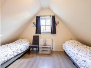 two beds in a room with a window at Limosa in Hippolytushoef