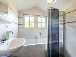 a bathroom with a tub and a sink and a shower at Limosa in Hippolytushoef +36 photos