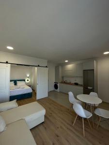 a living room with a bed and a table and chairs at Azzurre Premium Aparthotel in Sarandë