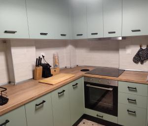 a kitchen with white cabinets and a wooden counter top at The Vintage House in Nea Moudania