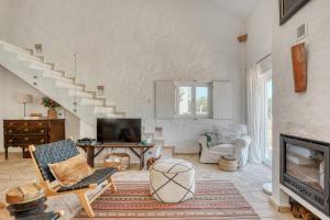 a living room with a staircase and a tv at The Pink Stork Villa in Alcácer do Sal