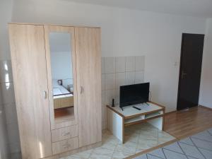 a room with a mirror and a desk with a television at Hostel Vera - Airport Podgorica in Podgorica
