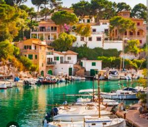 a group of boats docked in a harbor with buildings at Hostal Bernareggi in Cala Figuera