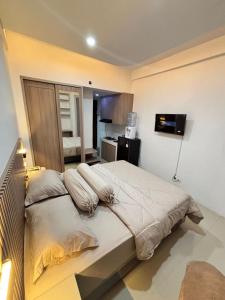 a bedroom with a bed with pillows on it at The alt room by Vivo apartemen in Yogyakarta