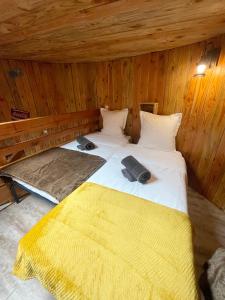a bedroom with two beds in a wooden cabin at La Cabane Tonneau - Les Pieds dans le Pré in Les Landes-Génusson