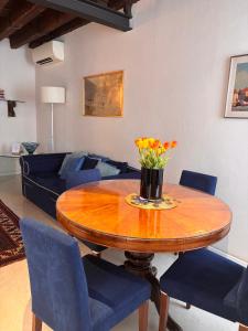a living room with a wooden table and blue chairs at Sarai Apartments in Venice